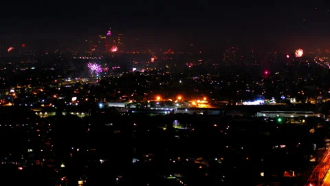 Aerial Panning Shot Of Fireworks Exploding Over City At Night, Drone Flying Over Stock Footage 243884068