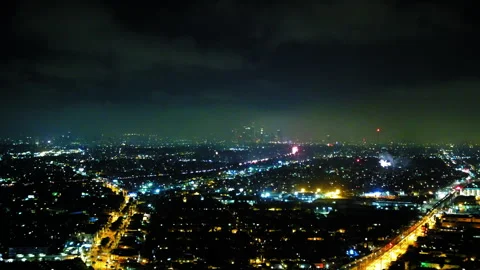 Aerial Panning Shot Of Fireworks Exploding Over Buildings In City At Night - Stock Footage 255404315