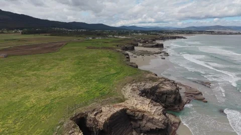 Aerial panorama of beach cliffs and rock arches at low tide Stockbeeldmateriaal 343324096