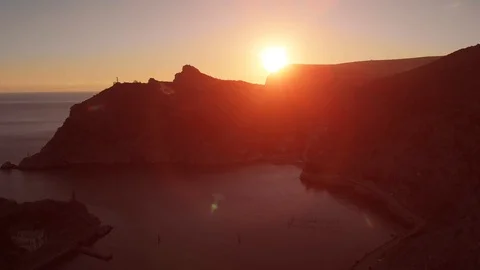 Aerial panorama of bright red dramatic beautiful sunset over mountains and sea Stock Footage 107873583