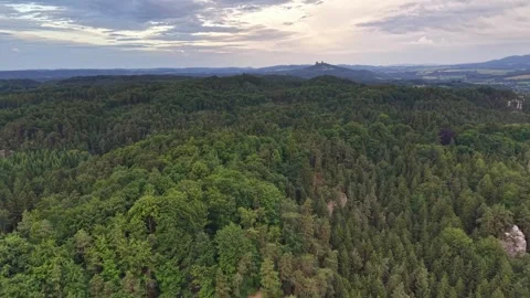 Aerial panorama of dense evergreen forest around jagged rock pillars, rolling Stock Footage 345286640