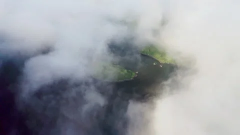 Aerial panorama. Dense white clouds cover dark water pond with green shoreline Stock Footage 169092273