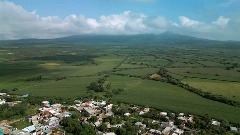 Aerial panorama of green crop fields with hills and a cloudy sky Stock Footage 342089195