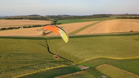 Aerial panorama of paragliding pilot with paramotor flying midair above 库存影片 334684029