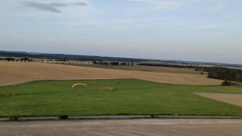 Aerial panorama of paragliding pilot with paramotor flying midair above 库存影片 334684038