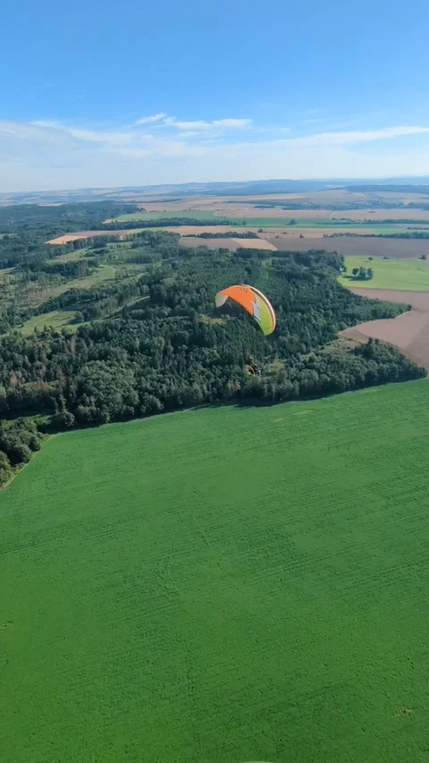Aerial panorama of paragliding pilot with paramotor flying midair above 库存影片 334718784