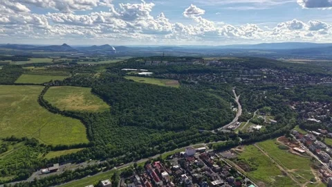 Aerial panorama of patchwork fields and dense townscape under bright cloudy sky Stock Footage 345286645