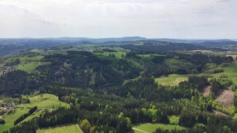 Aerial panorama of rolling countryside with patchwork fields, dense forests, Stock Footage 342355267