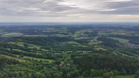 Aerial panorama of rolling countryside with patchwork fields, forested hills, Stock Footage 347913966