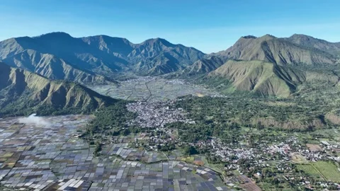 Aerial panorama of Sembalun with its patchwork rice fields and dramatic mountain Stock Footage 311142599