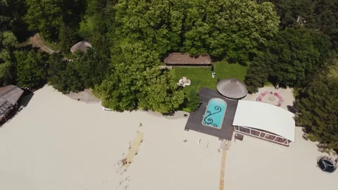 Aerial panorama view of a empty swimming pool with clear water, green trees all Stock Footage 321944366