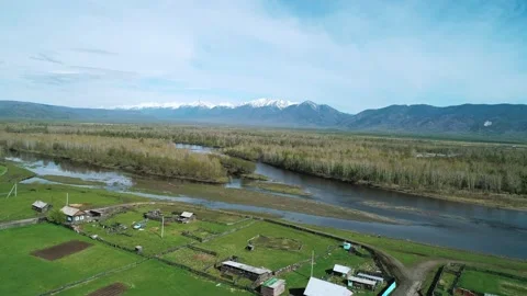 Aerial panoramic landscape of snow capped Sayan Mountains, river and little Stock Footage 211820135