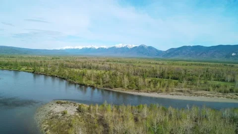 Aerial panoramic landscape of snow capped Sayan Mountains, valley and river on a 스톡 동영상 211820249