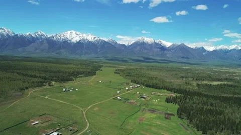 Aerial panoramic landscape of snow capped Sayan Mountains and little village in Video stock 211825810