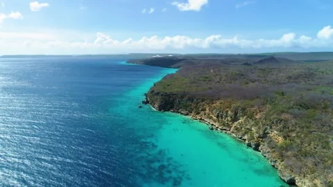 Aerial panoramic, sandy coastline cliffs and steep caribbean drop off into Stock Footage 247540027