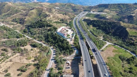 Aerial panoramic shot of a highway passing a mountain monastery Stock Footage 344105474