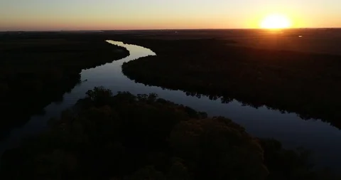 Aerial panoramic view of calm river at sunset. Following silhouette of boat 스톡 동영상 119084800