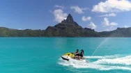 Aerial - Panoramic View Of Couple Riding Jet Ski In Luxury Bora Bora Resort Stock Footage
