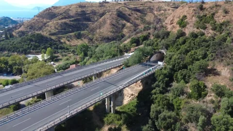 Aerial panoramic view of highway overpass leading to mountain tunnels Stock Footage 343962274