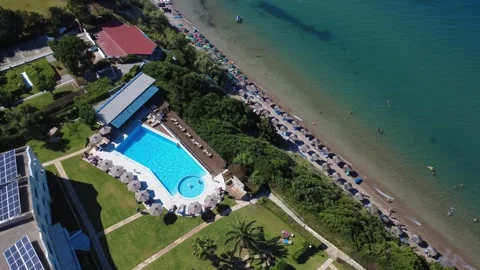 Aerial panoramic view of large resort pool by a crowded beach in Greece Stock Footage 343941020