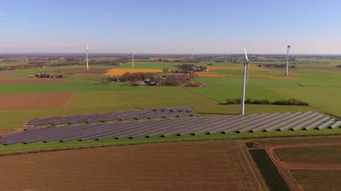 Aerial panoramic view of a massive solar panel farm and wind turbines Video stock 337562512