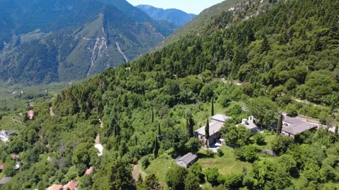 Aerial panoramic view of monastery hidden in forested mountain slope Stock Footage 343948490
