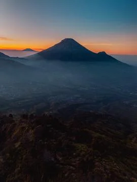 An aerial panoramic view of Mount Sindoro set against a golden-blue sky 库存照片