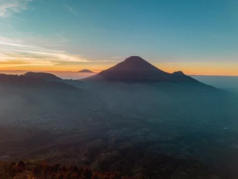 An aerial panoramic view of Mount Sindoro set against a golden-blue sky 库存照片
