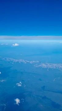 Aerial panoramic view of mountain range and open landscape captured from airplan Stock Photos