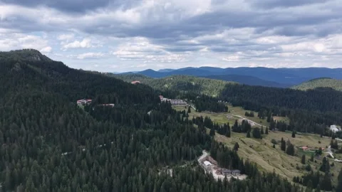 Aerial panoramic view of a mountain resort surrounded by dense pine forest 库存影片 341797785