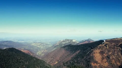 Aerial panoramic view of mountain ridges and green forest valley under blue sky Stock Footage 332047722