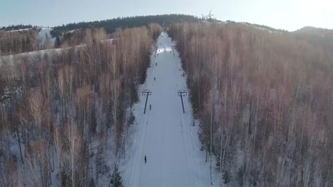 Aerial panoramic view of the moving ski-lifts between the trees in winter Stock Footage 163137377