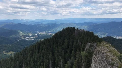 Aerial panoramic view over vast mountain ranges and forest valleys under cloudy  Video stock 341801238