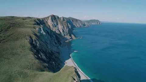 Aerial panoramic view of the rocky cliffs seaside and waves are crashing to the Stock Footage 167718748