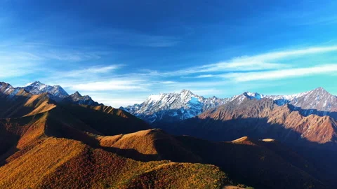 Aerial: Panoramic view of snow-capped mountain peaks. Snowcapped peaks. Stockbeeldmateriaal 143890073