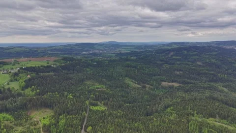 Aerial panoramic view sweeping rolling green hills, forest valleys, patchwork Stock Footage 347913997