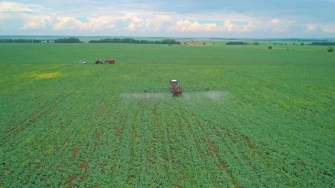 Aerial panoramic view of a tractor machine spraying the field with pesticides Stock Footage 197059208
