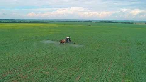 Aerial panoramic view of a tractor machine spraying the field with pesticides Stock Footage 197059481