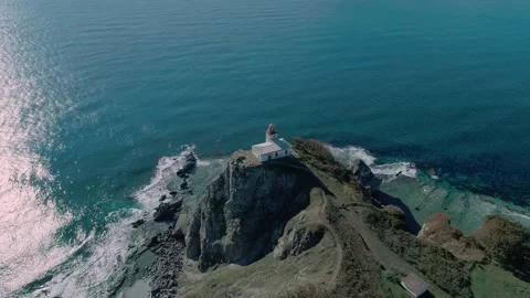 Aerial panoramic view of white lighthouse on the rocky cliff at seaside. Waves Stock Footage 167299381