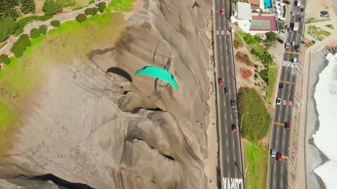 Aerial paragliding flight over cliffs and oceanfront highway in Miraflores, Peru 動画素材 311800302