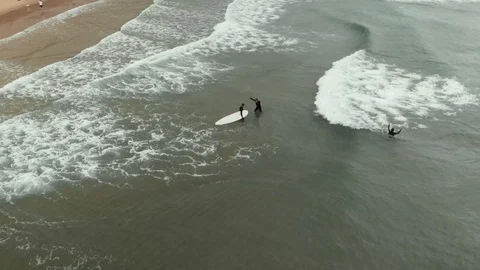 Aerial parallax view surf instructor explaining novice pupil how to catch wave Stock-Footage 108858403