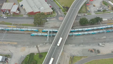 Aerial parallel tracking of train moving along through modern developed Video stock 218433578