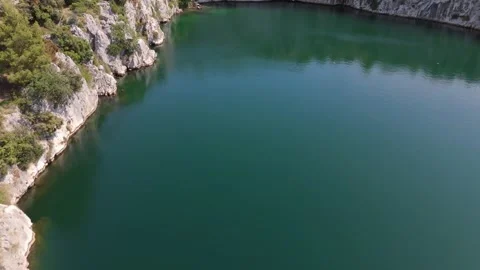 Aerial parallel view of Dragon Eye Lake surrounded by cliffs and pines Croatia 動画素材 337195154