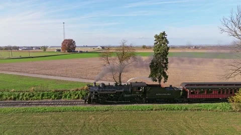 Aerial Parallel View of a Steam Train Traveling Behind Trees as it Travels .. Stock Footage 232909126