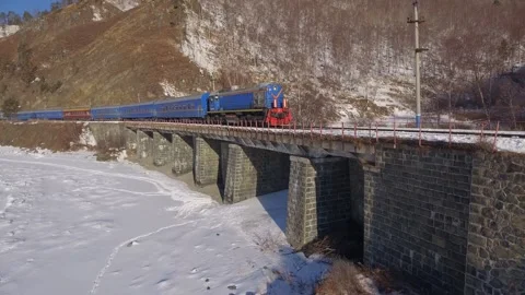 Aerial passenger train ride across Soviet bridge winter Circum-Baikal Railway 4k Stock Footage 317963674