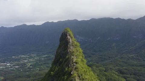 Aerial passing sharp sunlit mountain ridge covered with vegetation, Hawaii Stock Footage 126601915