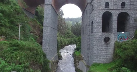 Aerial passing through a brick arch and over a river in southern Colombia. Vídeos de archivo 72611409