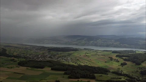 Aerial of patched green fields, Approaching Rain Storm East Of Lake Hallwil Vidéo 108610053