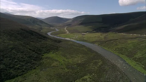 Aerial of path through rolling hill covered in grass, Cairngorms - Glen Avon Stock Footage 108583432