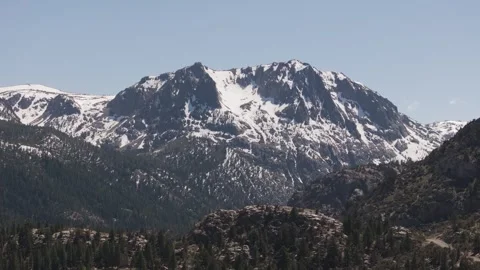 Aerial ped down of snowy mountain range and pine forest near June Lake, Stock Footage 277872358